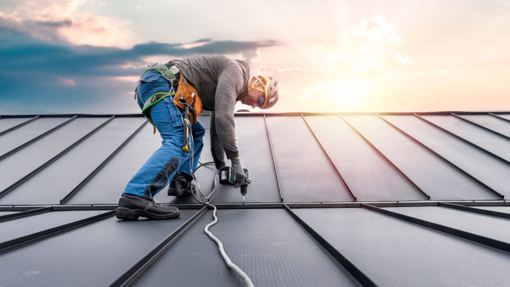 Roofer installing a metal roof